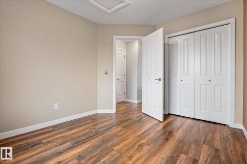Warm wood-finish flooring complements light neutral walls - 5407 204 Street, Edmonton, AB - Indoor Photo Showing Other Room