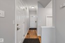 Entryway featuring wood-finish flooring, light gray wall paint, white trim, and a paneled front door with a window - 5407 204 Street, Edmonton, AB  - Indoor Photo Showing Other Room 