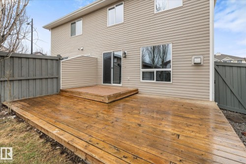Expansive wood deck with a raised section, accessible via a sliding glass door - 5407 204 Street, Edmonton, AB - Outdoor With Deck Patio Veranda With Exterior