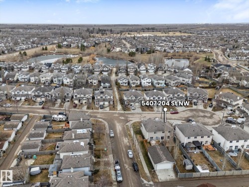 Residential neighborhood featuring a series of detached homes with grey roofs and varied exterior finishes - 5407 204 Street, Edmonton, AB - Outdoor With View