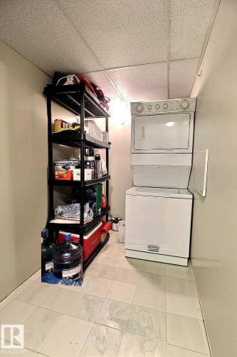 Stacked white washer and dryer unit - 413 279 Suder Greens Drive, Edmonton, AB - Indoor Photo Showing Laundry Room