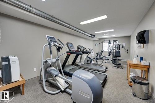 Fitness center featuring various exercise machines, recessed overhead lighting, and exposed ductwork - 413 279 Suder Greens Drive, Edmonton, AB - Indoor Photo Showing Gym Room