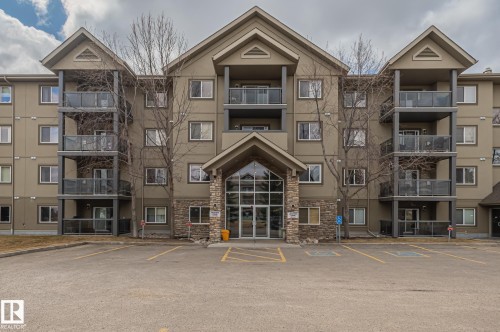 Multi-story building featuring a central stone-clad entrance with a vaulted portico - 413 279 Suder Greens Drive, Edmonton, AB - Outdoor With Facade