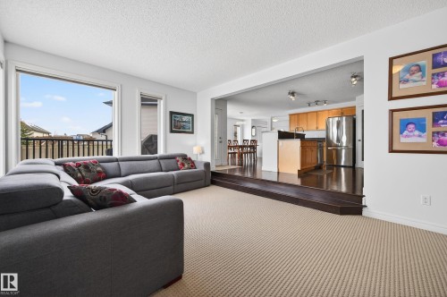 Spacious living area featuring neutral-toned carpeting, ample natural light, and an open-concept design - 8477 Sloane Crescent, Edmonton, AB - Indoor Photo Showing Living Room