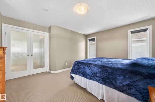 Neutral-toned walls complement the textured beige carpeting in this room - 8477 Sloane Crescent, Edmonton, AB - Indoor Photo Showing Bedroom