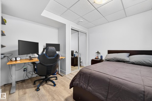 Bedroom featuring light wood-finish flooring, white walls, and a drop ceiling - 8477 Sloane Crescent, Edmonton, AB - Indoor Photo Showing Bedroom