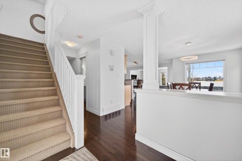 Open concept interior featuring dark wood-finish flooring and light-toned walls - 8477 Sloane Crescent, Edmonton, AB - Indoor Photo Showing Other Room