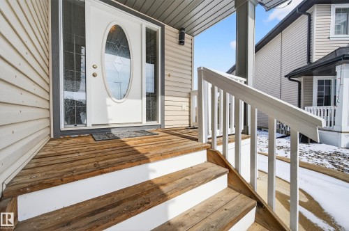 Covered front porch featuring wood steps with white risers and white railings - 8477 Sloane Crescent, Edmonton, AB - Outdoor With Exterior