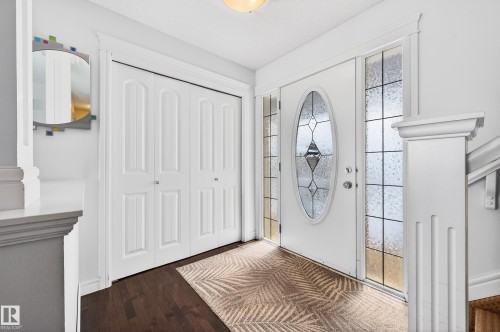 Entryway featuring a white door with an oval decorative glass insert, complemented by frosted glass sidelites - 8477 Sloane Crescent, Edmonton, AB - Indoor Photo Showing Other Room