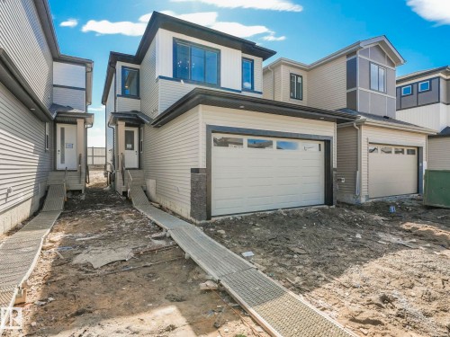 Contemporary two-story residence featuring light-colored horizontal siding and dark trim accents - 272 Munn Way, Leduc, AB - Outdoor