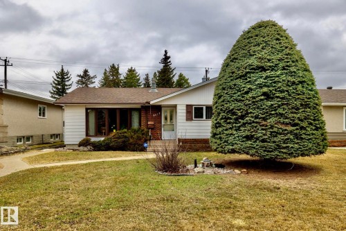 Front exterior featuring white siding, a brick accent wall, and a brown shingle roof - 8612 68A Street, Edmonton, AB - Outdoor