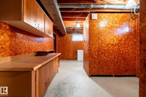 Utility space featuring built-in wood cabinetry, a wood-finish countertop, and overhead wood-finish storage - 8612 68A Street, Edmonton, AB - Indoor