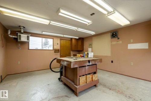 Utility room featuring concrete flooring, a window, and overhead fluorescent lighting - 8612 68A Street, Edmonton, AB - Indoor Photo Showing Garage