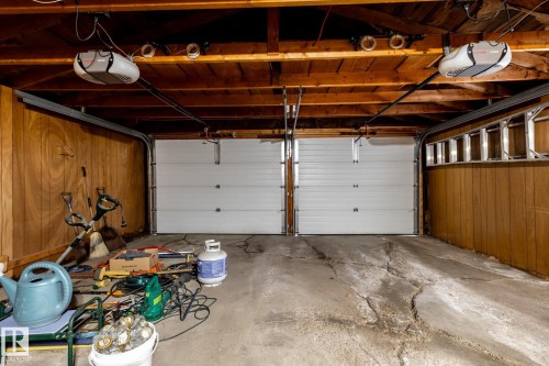 Two white sectional garage doors with openers - 8612 68A Street, Edmonton, AB - Indoor Photo Showing Garage