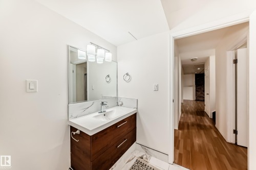 Bathroom vanity with a white rectangular undermount sink, a chrome faucet, and a wall-mounted rectangular mirror - 2039 48 Street, Edmonton, AB - Indoor Photo Showing Bathroom