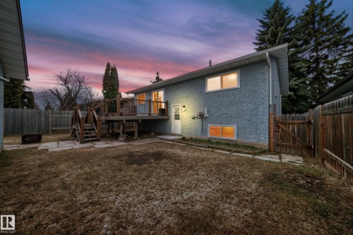 Rear exterior featuring a raised wooden deck with railings, a privacy fence, and a walk-out door - 2039 48 Street, Edmonton, AB - Outdoor With Deck Patio Veranda