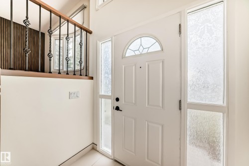 Entryway with a paneled white door featuring an arched leaded glass transom - 2039 48 Street, Edmonton, AB - Indoor Photo Showing Other Room