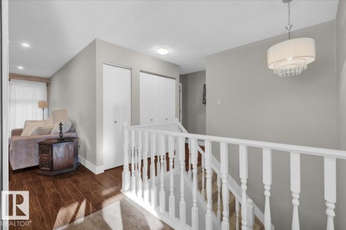 Hall featuring an upstairs landing, a textured ceiling, and wood finished floors - 3515 20 Avenue, Edmonton, AB - Indoor Photo Showing Other Room