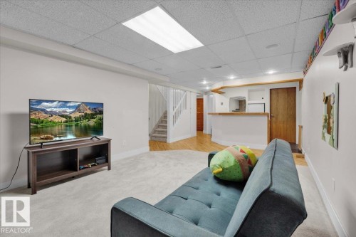 Living area featuring carpet, stairway, and a drop ceiling - 3515 20 Avenue, Edmonton, AB - Indoor