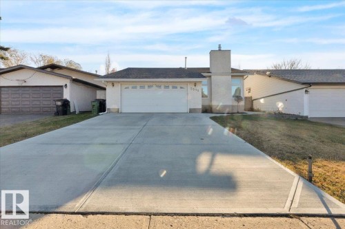 View of front of property featuring a chimney, an attached garage, and concrete driveway - 3515 20 Avenue, Edmonton, AB - Outdoor