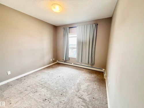 Room with neutral-toned walls, white trim, and light gray carpeting - 437 5504 Schonsee Drive, Edmonton, AB - Indoor Photo Showing Other Room