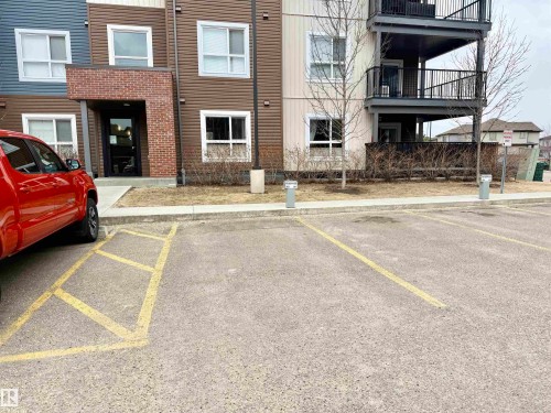 Multi-level building exterior featuring brown and blue siding, white-framed windows, and a brick-accented entry - 437 5504 Schonsee Drive, Edmonton, AB - Outdoor With Balcony