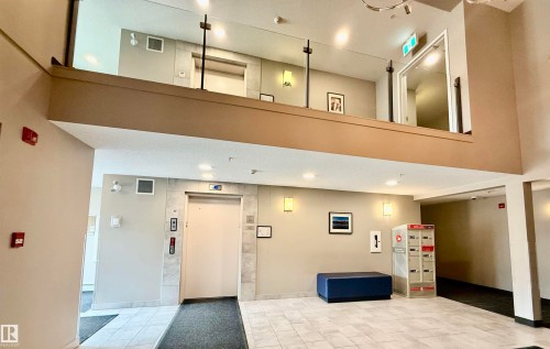 Two-story lobby featuring a glass-paneled upper-level railing - 437 5504 Schonsee Drive, Edmonton, AB - Indoor Photo Showing Other Room