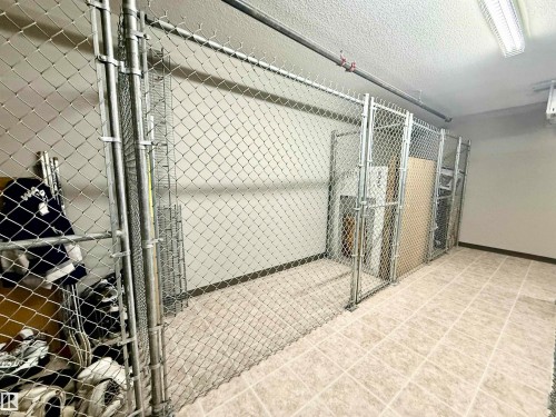 Chain-link storage cages within a tiled-floor room - 437 5504 Schonsee Drive, Edmonton, AB - Indoor