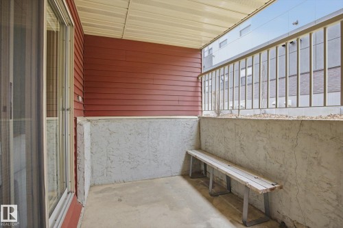 Private patio featuring a built-in bench, concrete flooring, and red siding - 103 10732 86 Avenue, Edmonton, AB -  Photo Showing Other Room