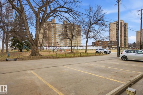 Expansive paved parking area featuring marked spaces - 103 10732 86 Avenue, Edmonton, AB - Outdoor