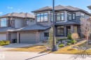 Modern facade featuring extensive stonework and dark siding - 1313 Hainstock Way, Edmonton, AB  - Outdoor With Facade 