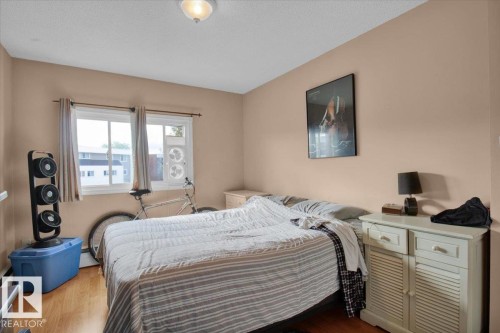 This inviting bedroom features light wood flooring, neutral tone walls, and a window with blinds - 412 2908 116A Avenue, Edmonton, AB - Indoor Photo Showing Bedroom