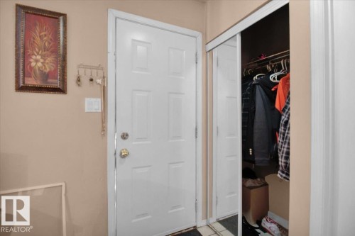 Entryway with a white paneled door and a bi-fold mirrored closet - 412 2908 116A Avenue, Edmonton, AB - Indoor Photo Showing Other Room