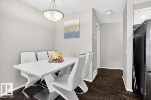 Dining space with dark wood-style floors and a textured ceiling - 47 230 Edwards Drive, Edmonton, AB - Indoor Photo Showing Dining Room