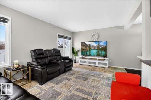 Living room with baseboards and stone finish flooring - 47 230 Edwards Drive, Edmonton, AB - Indoor Photo Showing Living Room