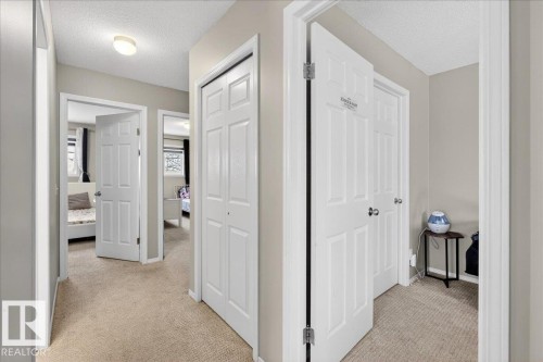 Hallway featuring light colored carpet and a textured ceiling - 47 230 Edwards Drive, Edmonton, AB - Indoor Photo Showing Other Room