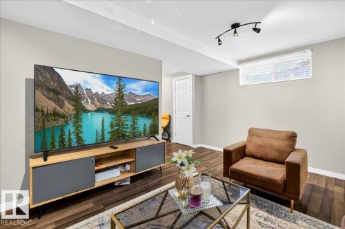 Family room featuring baseboards and wood finished floors - 47 230 Edwards Drive, Edmonton, AB - Indoor