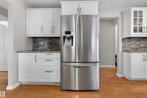 Stainless steel French door refrigerator set within white shaker cabinetry - 17120 103 Street, Edmonton, AB - Indoor Photo Showing Kitchen With Stainless Steel Kitchen