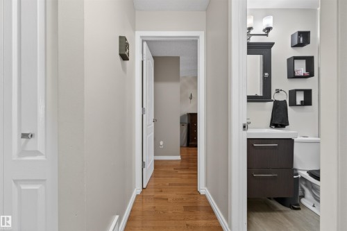 Hallway with wood-finish flooring, light neutral wall paint, and white trim - 17120 103 Street, Edmonton, AB - Indoor Photo Showing Other Room