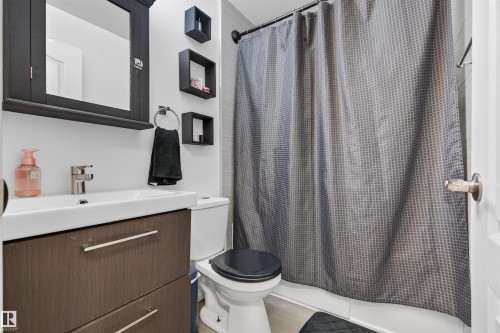 Bathroom featuring a floating wood-finish vanity with an integrated sink and chrome faucet - 17120 103 Street, Edmonton, AB - Indoor Photo Showing Bathroom