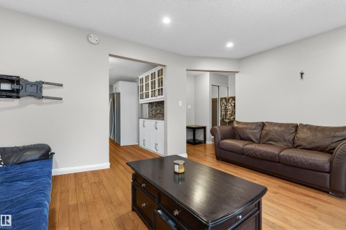 Light-colored walls complement the warm wood-finish flooring - 17120 103 Street, Edmonton, AB - Indoor Photo Showing Living Room