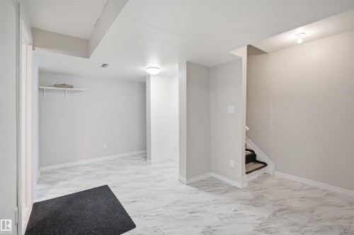 Spacious finished area featuring light-toned walls, recessed lighting, and marble-look tile flooring - 1124 37A Avenue, Edmonton, AB - Indoor