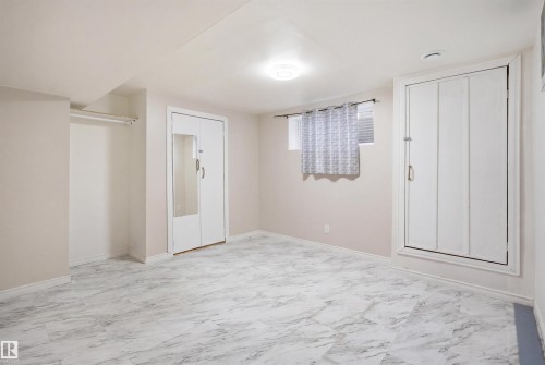 Spacious room featuring light-toned walls, white baseboards, and a patterned tile floor - 1124 37A Avenue, Edmonton, AB - Indoor Photo Showing Other Room