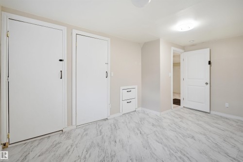 Contemporary flooring with a marbled pattern, light neutral wall paint, white trim, and recessed built-in drawers - 1124 37A Avenue, Edmonton, AB - Indoor Photo Showing Other Room