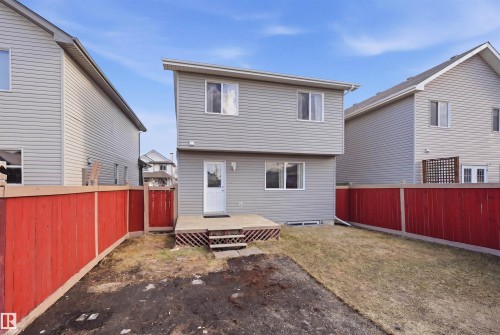 Rear exterior of a two-story residence featuring light gray horizontal siding and white-framed windows - 1124 37A Avenue, Edmonton, AB - Outdoor With Exterior
