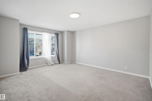 Spacious room featuring light gray wall paint and matching gray carpet - 1124 37A Avenue, Edmonton, AB - Indoor Photo Showing Other Room