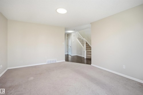 Spacious room featuring neutral carpeting and light-toned walls - 1124 37A Avenue, Edmonton, AB - Indoor Photo Showing Other Room