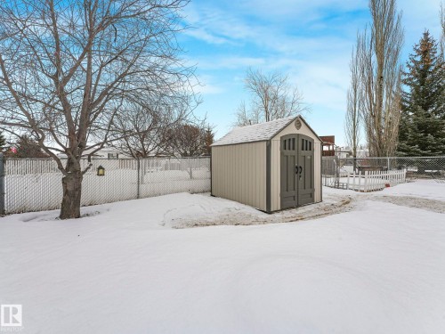 Backyard featuring a functional shed with a gabled roof, dual entry doors, and a decorative arch accent - 151 3400 48 Street, Stony Plain, AB - Outdoor