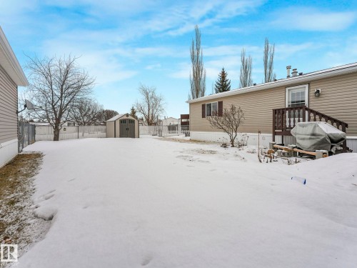 Exterior featuring horizontal siding, dark window shutters, and a rear deck with wood railing and steps - 151 3400 48 Street, Stony Plain, AB - Outdoor