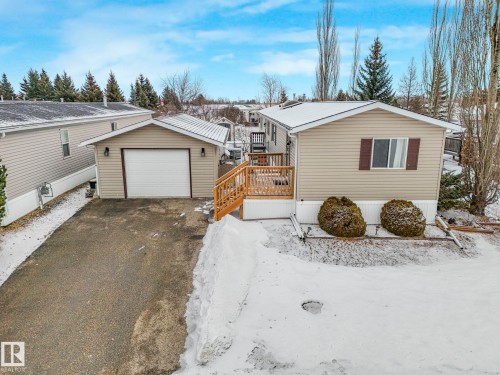 Detached garage with a white overhead door and an asphalt driveway - 151 3400 48 Street, Stony Plain, AB - Outdoor